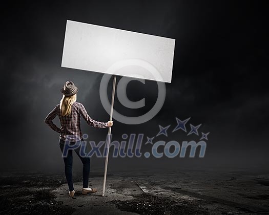 Young woman in casual carrying white blank banner Young woman in casual carrying white blank banner