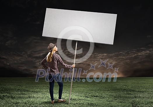 Young woman in casual carrying white blank banner Young woman in casual carrying white blank banner