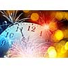 Conceptual image of clock with bokeh lights and firework