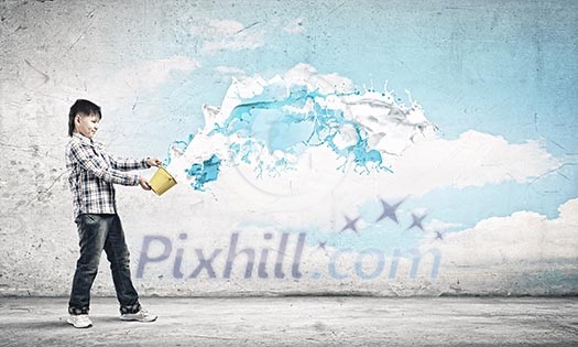 Cute boy splashing colorful paint from bucket Cute boy splashing colorful paint from bucket