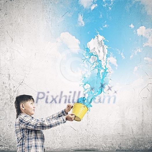 Cute boy splashing colorful paint from bucket Cute boy splashing colorful paint from bucket
