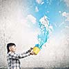 Cute boy splashing colorful paint from bucket