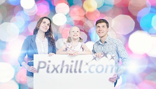 Young happy family with white blank banner. Place for text Young happy family with white blank banner. Place for text