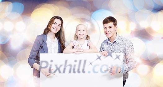 Young happy family with white blank banner. Place for text Young happy family with white blank banner. Place for text
