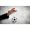 Close up of male hand holding football ball on rope