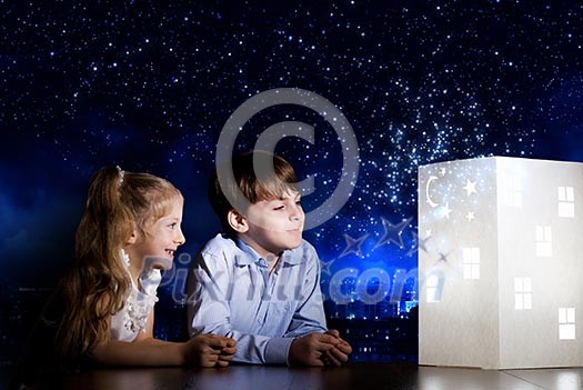 Cute little boy and girl looking at model of house Cute little boy and girl looking at model of house