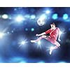 Young football player on stadium kicking ball