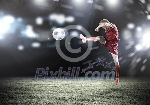 Young football player on stadium kicking ball Young football player on stadium kicking ball