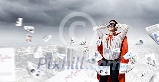 Young man in hero costume closing ears with palms Young man in hero costume closing ears with palms
