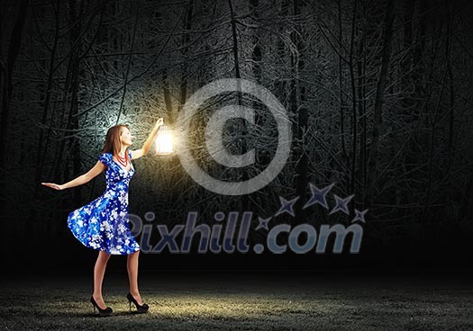 Young woman in blue dress walking in night wood Young woman in blue dress walking in night wood