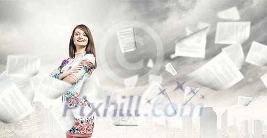 Young woman in casual and paper flying in air Young woman in casual and paper flying in air
