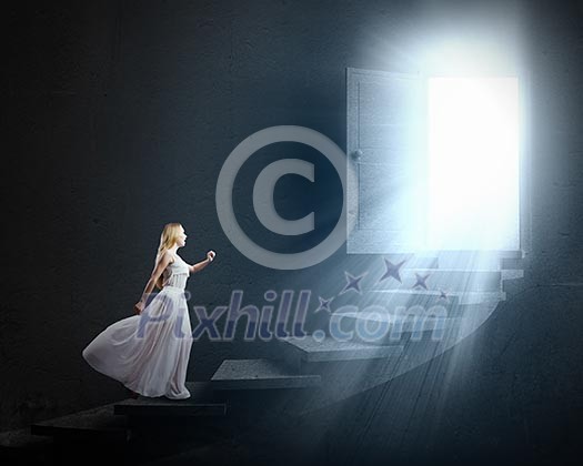 Young woman in white long dress walking up the staircase Young woman in white long dress walking up the staircase