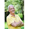 happy healthy and fit elderly man portrait  in green background park