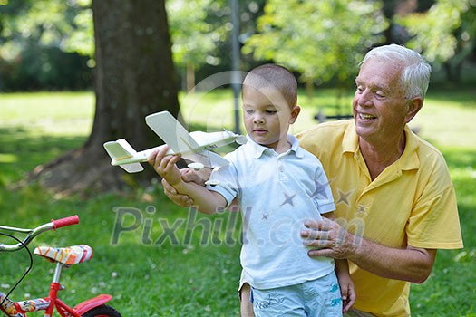 happy grandfather and child have fun and play in park happy grandfather and child have fun and play in park