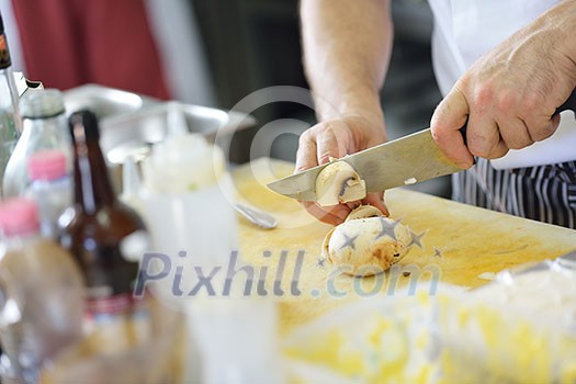 Handsome chef dressed in white uniform decorating pasta salad and seafood fish in modern kitchen Handsome chef dressed in white uniform decorating pasta salad and seafood fish in modern kitchen