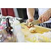 Handsome chef dressed in white uniform decorating pasta salad and seafood fish in modern kitchen
