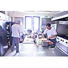 Handsome chef dressed in white uniform decorating pasta salad and seafood fish in modern kitchen