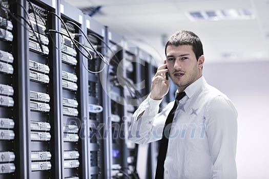 young business man computer science engeneer talking by cellphone at network datacenter server room asking for help and fast solutions and services young business man computer science engeneer talking by cellphone at network datacenter server room asking for help and fast solutions and services