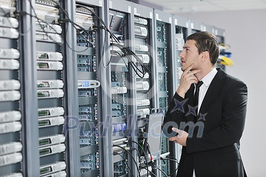 young handsome business man engeneer in datacenter server room young handsome business man engeneer in datacenter server room