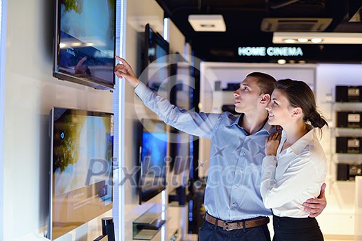 people in consumer electronics retail store looking at latest laptop, television and photo camera to buy people in consumer electronics retail store looking at latest laptop, television and photo camera to buy