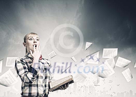 Woman in casual wear holding opened book in hands Woman in casual wear holding opened book in hands