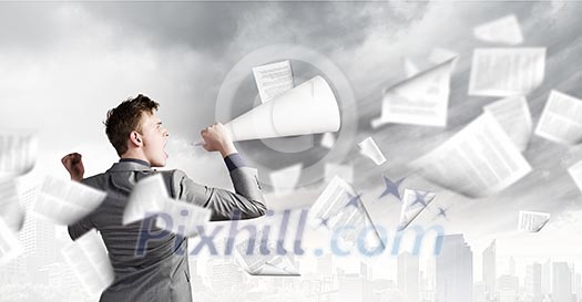 Young excited businessman screaming in paper trumpet Young excited businessman screaming in paper trumpet