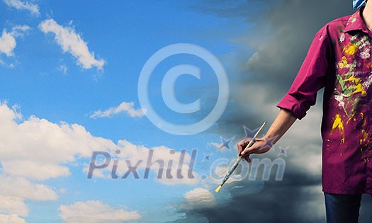 Young handsome man painter with brush in hand Young handsome man painter with brush in hand
