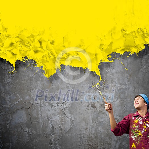 Young handsome man painter with brush in hand Young handsome man painter with brush in hand
