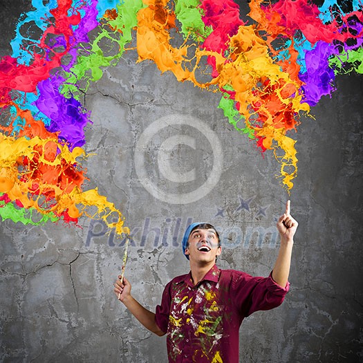 Young handsome man painter with brush in hand Young handsome man painter with brush in hand