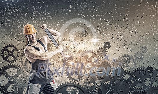 Strong man mechanic in uniform with spanner fixing mechanism Strong man mechanic in uniform with spanner fixing mechanism
