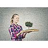 Young woman in casual holding opened book with green tree