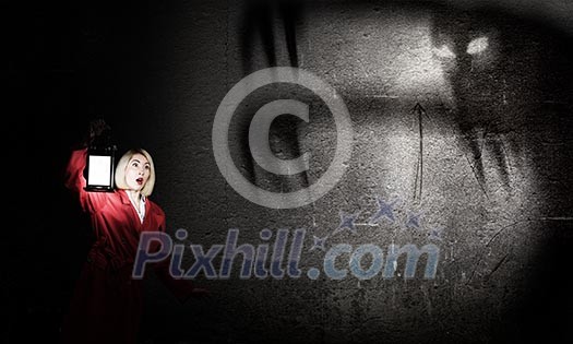 Young blond woman in red cloak with lantern Young blond woman in red cloak with lantern