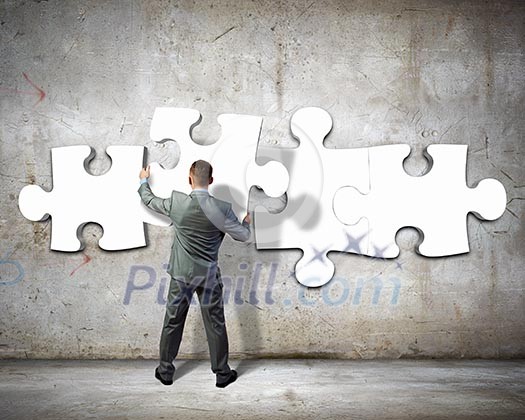 Image of businessman compiling macro white puzzle. Building business Image of businessman compiling macro white puzzle. Building business