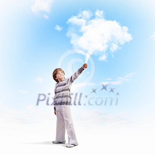 Image of little cute boy catching clouds in sky Image of little cute boy catching clouds in sky