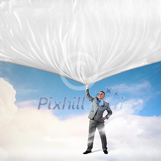 Image of young businessman pulling blank banner from above Image of young businessman pulling blank banner from above