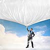 Image of young businessman pulling blank banner from above