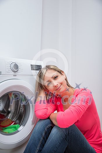 Housework: young woman doing laundry (shallow DOF; color toned image) Housework: young woman doing laundry (shallow DOF; color toned image)