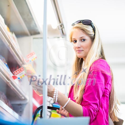 Beautiful young woman shopping in a grocery store/supermarket (color toned image) Beautiful young woman shopping in a grocery store/supermarket (color toned image)