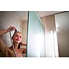 Young woman washing her hair with shampoo, taking a hot long shower