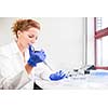 Portrait of a female researcher doing research in a lab (shallow DOF; color toned image)