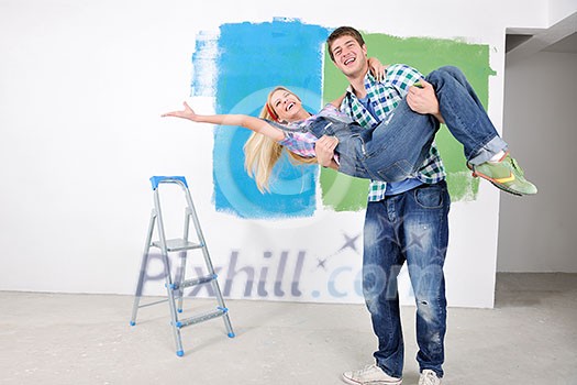 happy young couple paint in green and blue color white wall of their new home happy young couple paint in green and blue color white wall of their new home