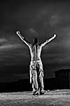 Man with his arms wide open outdoor against dark sky