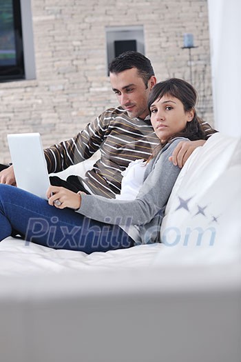 joyful couple relax and work on laptop computer at modern living room indoor home joyful couple relax and work on laptop computer at modern living room indoor home