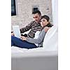 joyful couple relax and work on laptop computer at modern living room indoor home
