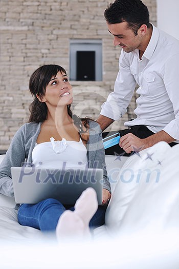 joyful couple relax and work on laptop computer at modern living room indoor home joyful couple relax and work on laptop computer at modern living room indoor home