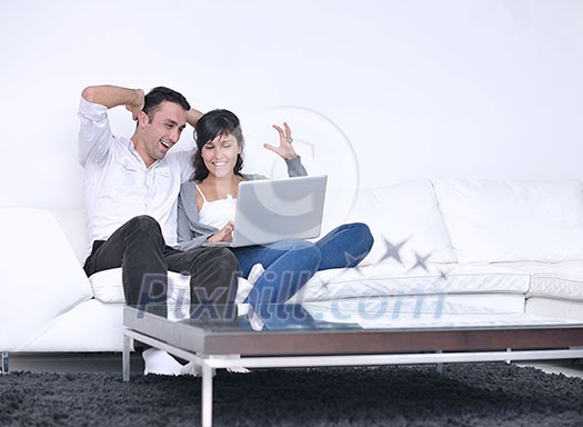 joyful couple relax and work on laptop computer at modern living room indoor home joyful couple relax and work on laptop computer at modern living room indoor home