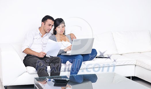joyful couple relax and work on laptop computer at modern living room indoor home joyful couple relax and work on laptop computer at modern living room indoor home