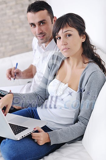 joyful couple relax and work on laptop computer at modern living room indoor home joyful couple relax and work on laptop computer at modern living room indoor home