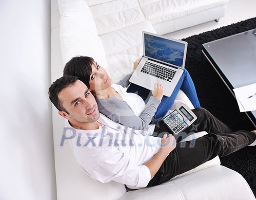 joyful couple relax and work on laptop computer at modern living room indoor home joyful couple relax and work on laptop computer at modern living room indoor home