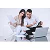 joyful couple relax and work on laptop computer at modern living room indoor home